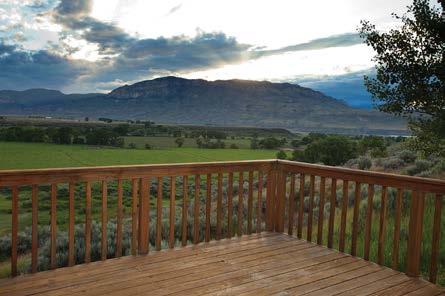 The great room, which enjoys stunning views of the South Fork Valley, allows access to an outdoor patio and stone fireplace.
