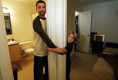 Amanda Lucidon / The Press-Enterprise Michael Carlin and his girlfriend's son, Logan Yost, 9, can be in all three rooms of Carlin's Corona condominium at once.