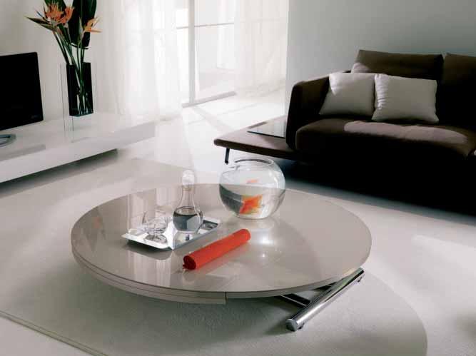 UNALTERABLE SURFACES - A ROUND TABLE OF MEDIUM SIZE COMES FROM THE ROTATION OF THE GLASS TOP. A SOLID STRUCTURE ALMOST DISAP- PEARS IN THE TABLE VERSION.