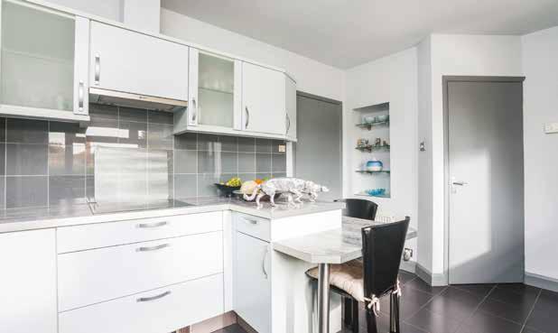 The kitchen comprises an integral fridge, dishwasher, inset Neff electric oven, grill microwave and warming drawer alongside a breakfast