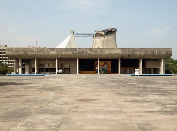 The Legislative Assembly completes the complex Located in the centre is the Open Hand Monument This metallic sculpture is the official emblem of Chandigarh and was also designed by Le Corbusier (text