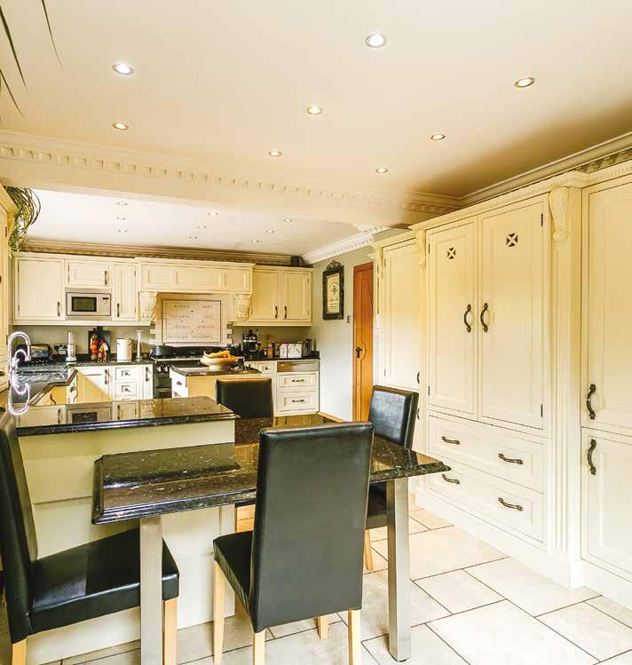 Kitchen A beautiful and bespoke kitchen set on a porcelain tiled floor with wall and floor mounted cream bespoke kitchen units with