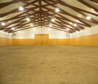 The attached barn holds six stalls with padded floors, a tack room storage area, equine wash facility, a bathroom, and a vet area.