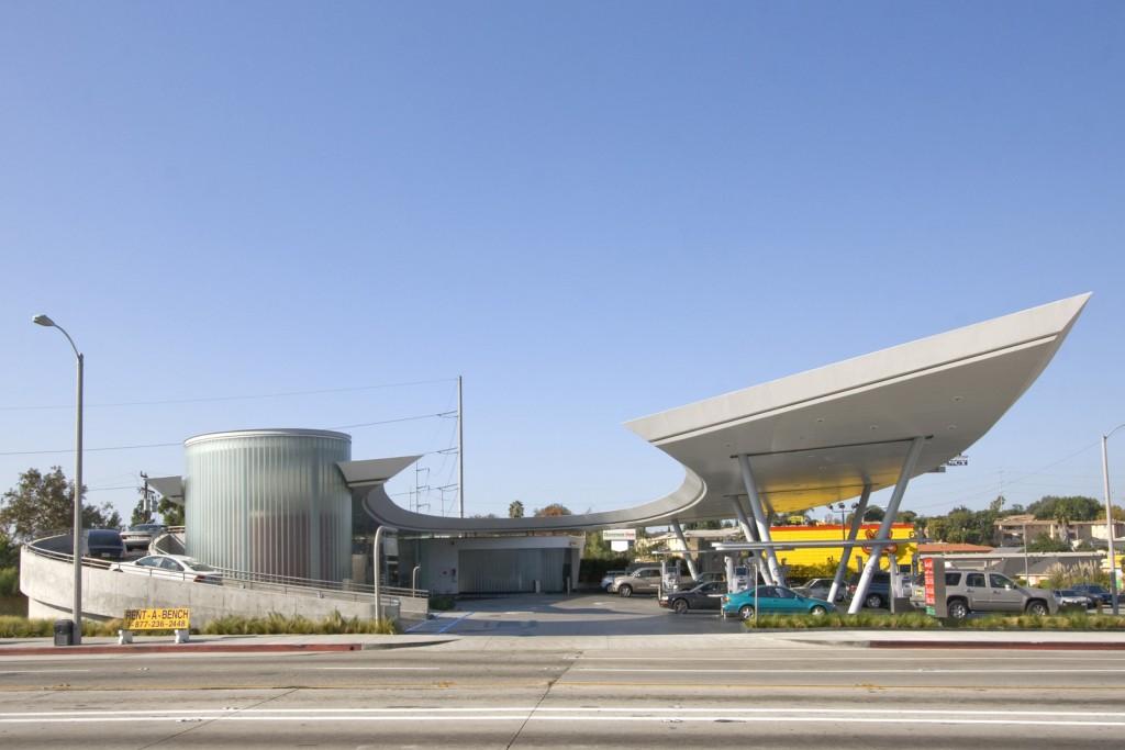 structure, swoops down from the sky to serve as the roof of the mini-market The form regains an upward momentum that carries it around the front of the market where it becomes a 30-foot canopy over