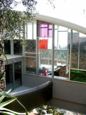 the space splits into two parts, with an outdoor spiral staircase leading from Mulholland Drive down into the living area Glass walls close in both