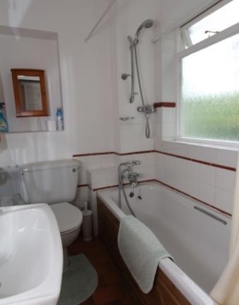 Bathroom 9 x 5 Fitted with a three piece white suite comprising bath with shower over, basin and wc. Terracotta flooring.