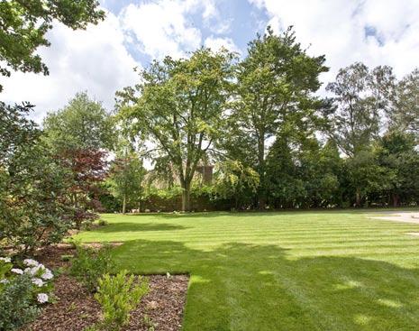 A path leads round the side of the property to an expansive terrace across the rear which leads onto the level lawn bordered by well stocked shrubbery beds.
