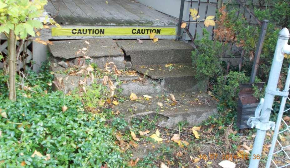 Caution tape covers the damaged front steps of this REO.