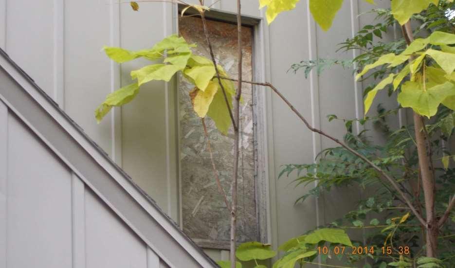 This REO also had hanging pieces of siding and a boarded window, detracting from the home s curb