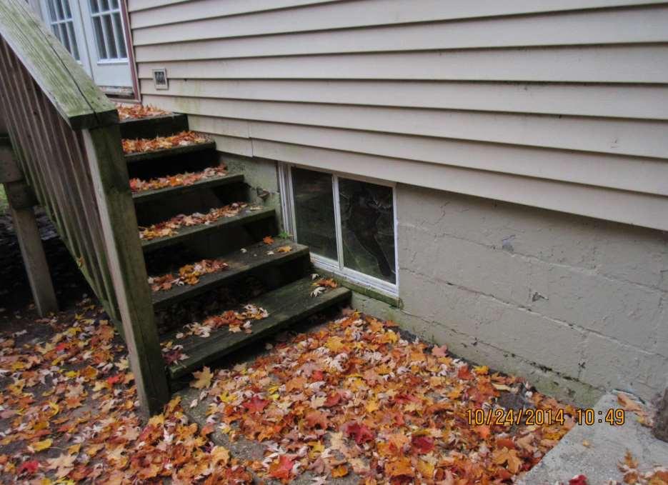 A broken window can be seen next to the steps that are covered in