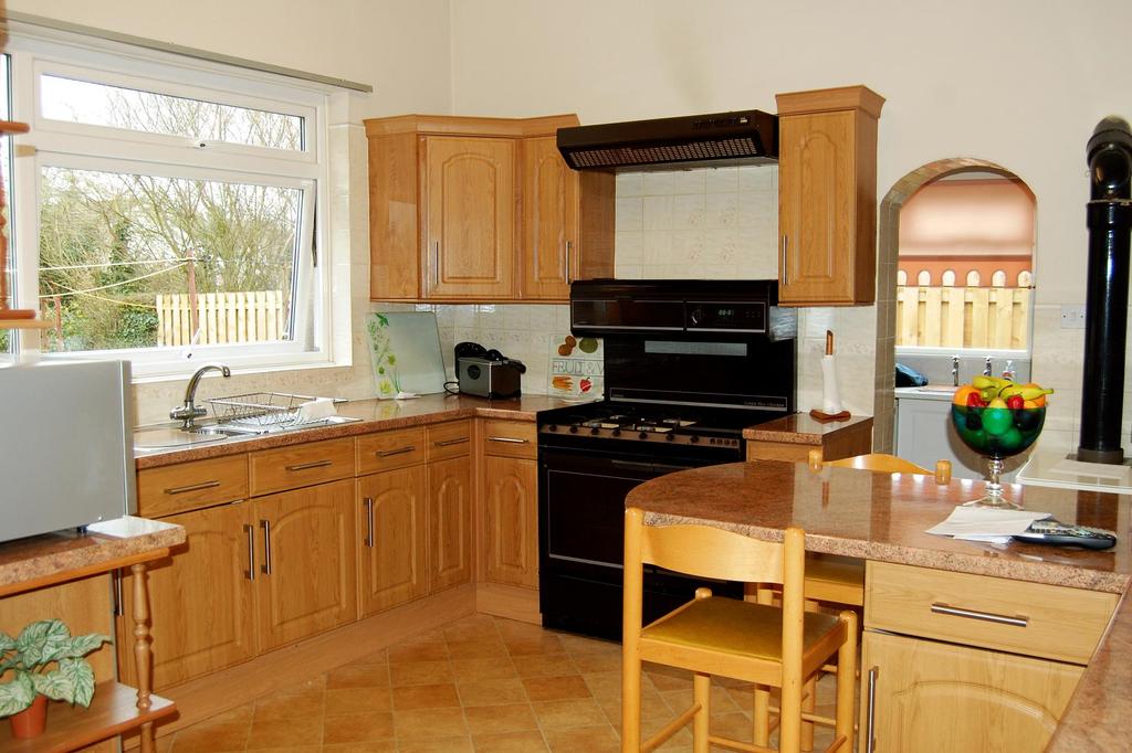 Kitchen The kitchen is a spacious room with ample fitted modern wood effect base and wall units, stainless steel sink