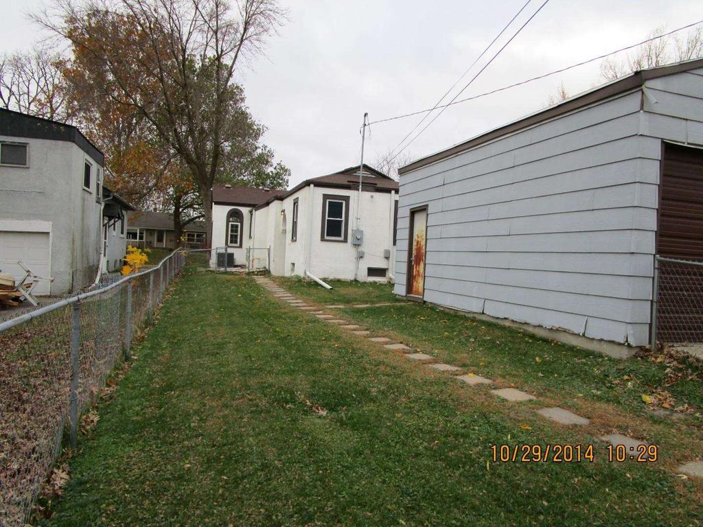 The side view shows that the grass on the property has been mowed and there is no trash, debris, or boarding at this property.