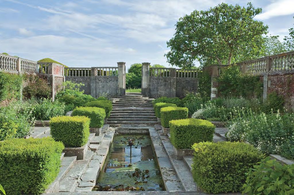 The charmingly antique gardens by Gertrude Jekyll, a frequent Lutyens collaborator, offer sweeping views of the Hampshire countryside. Below: In the sunken garden, rows of boxwood line a lily pond.