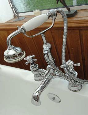 Free standing cast iron bath with antique style mixer taps and