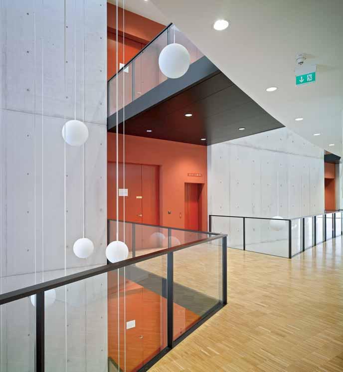 Recessed red walls distinguish themselves from the exposed concrete of the core and identify the laboratory entrances.