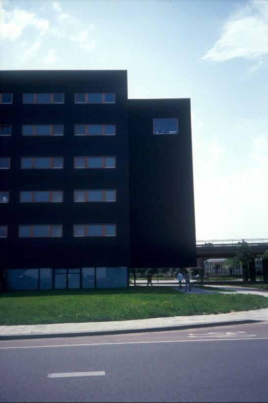 window strips in a dark brick façade, while the south facade is built of glass bricks with horizontal window bands The entrance is dominated by a large