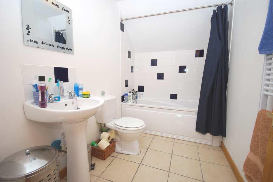 FAMILY BATHROOM Tiled round bath. Shower attachment at bath with shower rail and curtain.