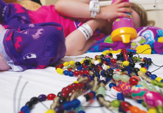 Beads of Courage stretch across the hospital bed of an EMMC pediatric patient.