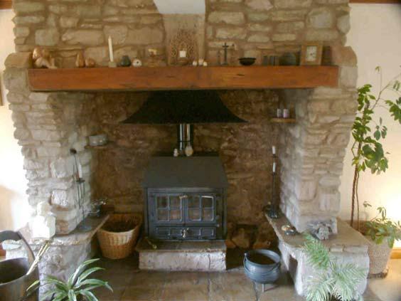 Multi-fuel stove in inglenook fireplace.