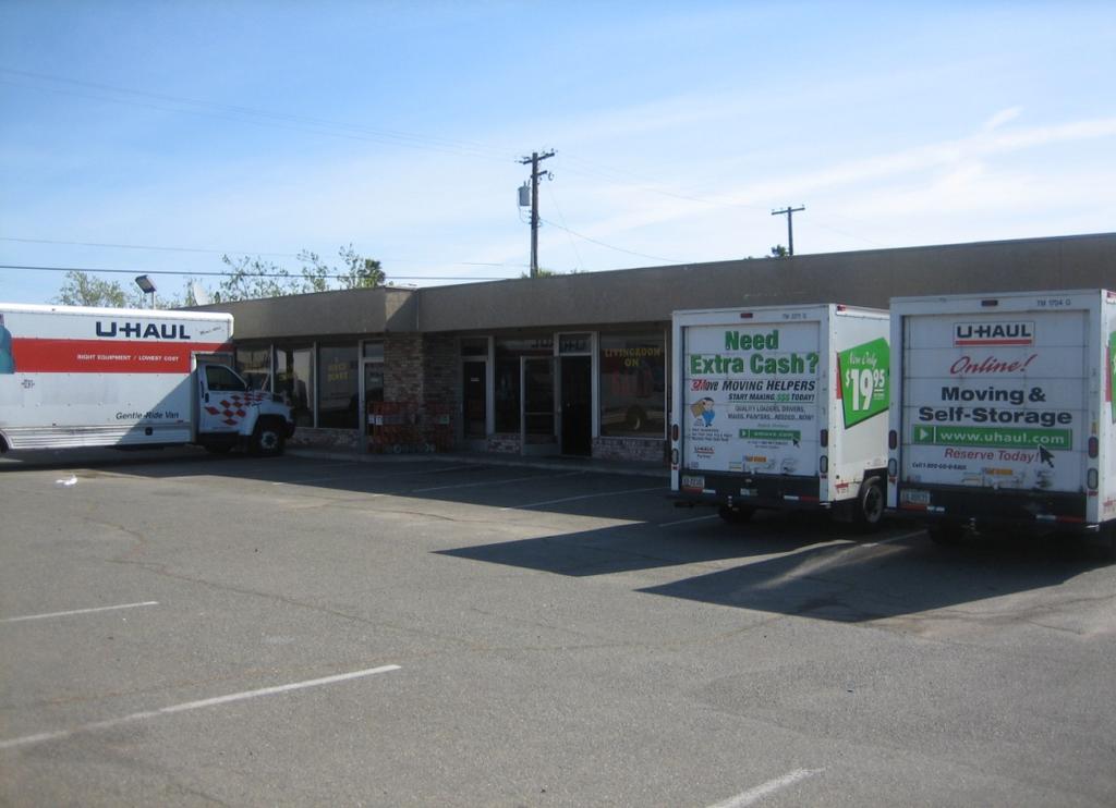 Photo of a recycling center located in the parking area on-site with U-Haul trucks parked in the background of the photo.