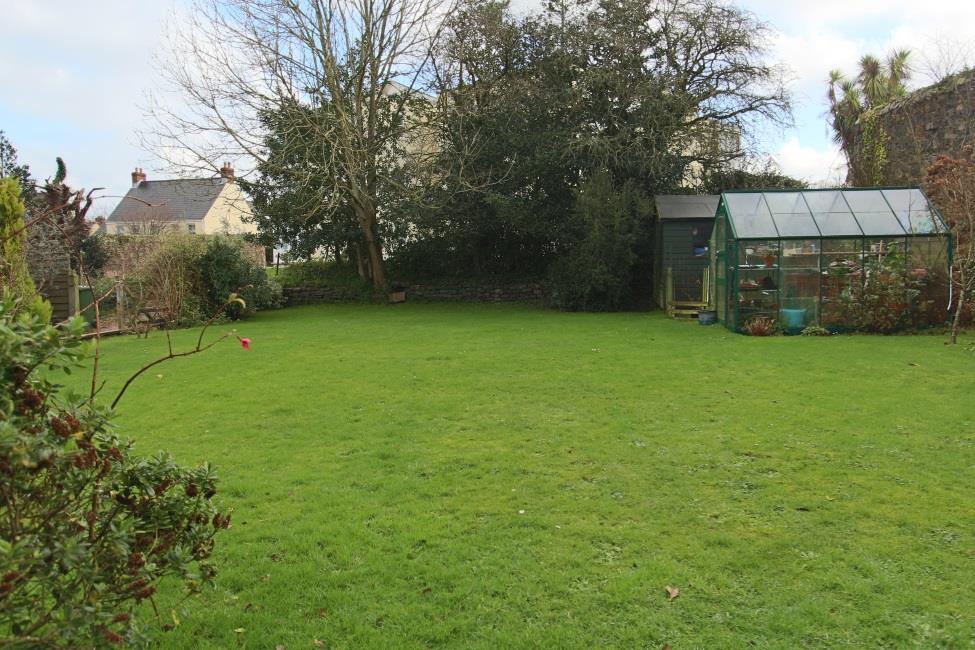 The front garden is laid to lawn with a timber garden shed and domestic green house.