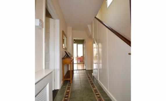 Window and part glazed wooden door with stained glass windows to: Entrance Hall 12' x 7'3 (3.66m x 2.21m) Tiled flooring. Under stairs storage cupboard. Stairs to First Floor.