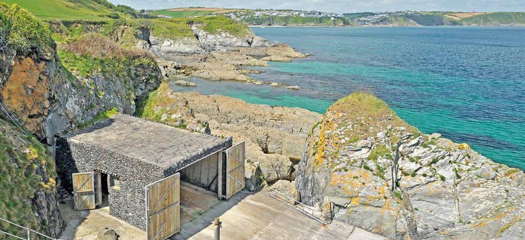 Steps lead down to a sheltered cove that has a private concrete slipway and a stone clad boat house with power and water