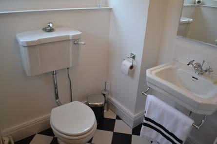 WC: Attractive Savoy two piece suite in white comprising of pedestal wash basin with tiled splash back and mirror and Victorian style radiator.