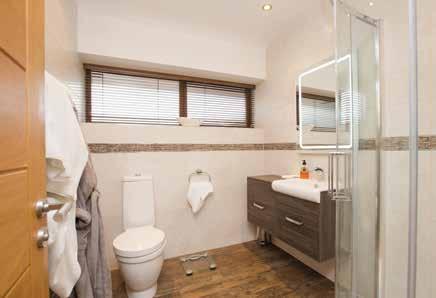 ENSUITE SHOWER ROOM: Half pedestal wash habd basin, fully tiled shower cubicle with drencher shower head, heated towel rail, tiled floor.