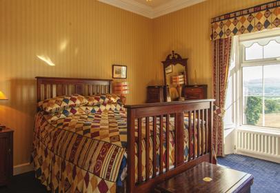 The room is very well lit with three windows. Large ornate marble mantelpiece and double doors leading out to the beautiful views over the countryside.
