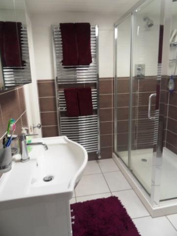 , fully tiled shower cubicle and wash hand basin in vanity unit.