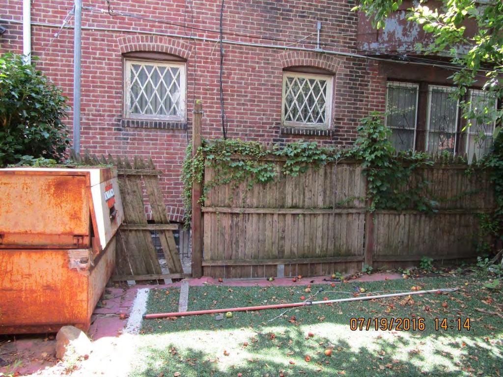 In the backyard there is more debris in the yard and the fence is broken, leaving the back of