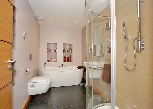 FAMILY BATHROOM A spacious Bathroom comprising wall hung WC and wash hand basin, Jacuzzi bath and large separate shower cubicle with rainfall shower head.