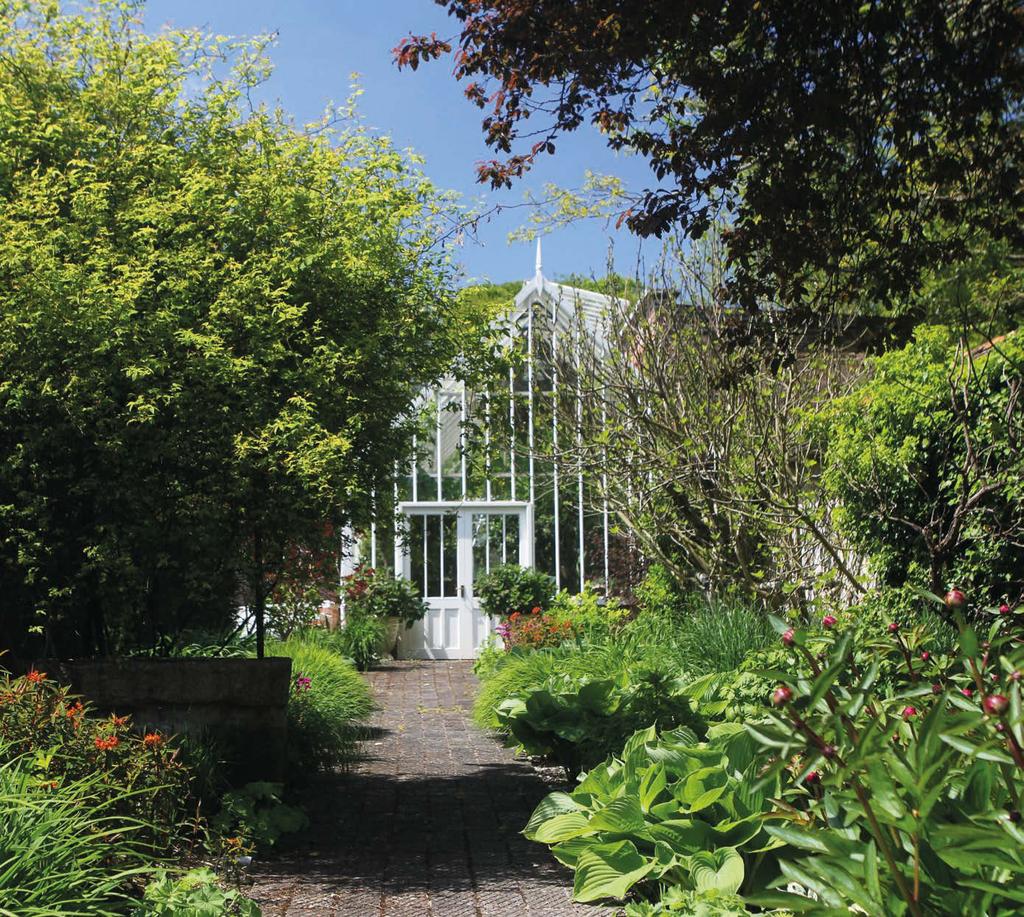 Sitting at the end of a walled garden is a large heated greenhouse, currently housing banana, orange and lemon trees.