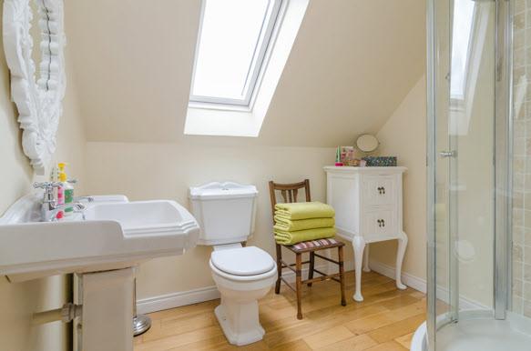 ENSUITE SHOWER ROOM: Solid oak flooring, attractive white suite