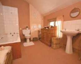 Single glazed wooden window to side elevation. BATHROOM A spacious bathroom having suite comprising of panelled bath, pedestal wash hand- basin and closecoupled w.c. Tiling to splash areas.