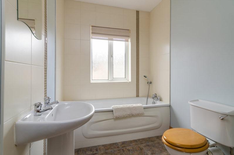 LUXURY BATHROOM: White suite com,prising low flush wc, pedestal wash hand basin with splash