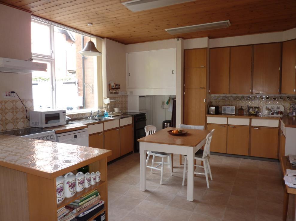 It has a stainless steel sink with taps and tile splashback. There is a gas and electric cooker point with an overhead extractor fan, pine panelled ceiling, large glazed window and exterior door.