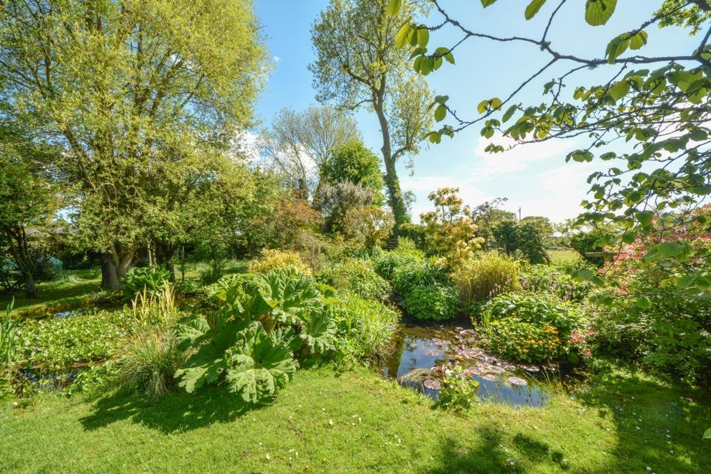 Frontage An attractive enclosed cottage garden with established borders, path and lawn Brick wall to the side Driveway Double gates with vehicular leading to a parking area The owners also park on