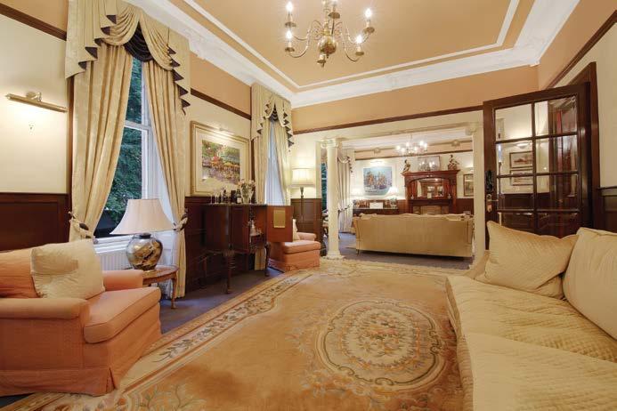 The ground floor opens into an imposing reception hall with feature leaded glass window, and consists of an elegant lounge of grand proportions featuring ornate pillars, two fireplaces and two bay