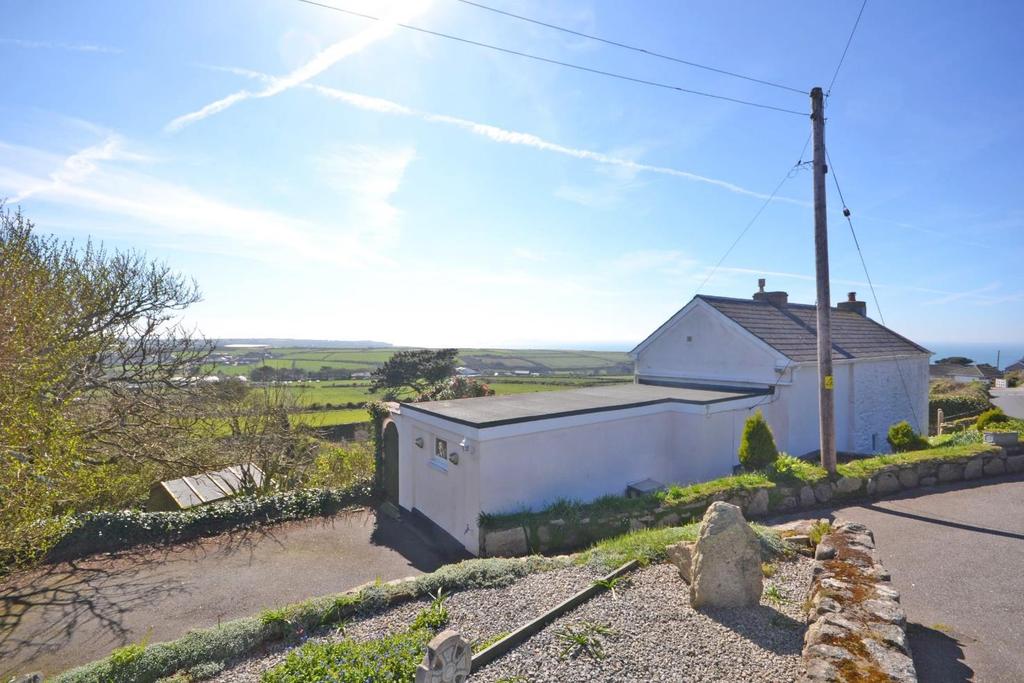 9 gate opens through a wall from the driveway and onto a wide path along the seaward facing side of the cottage with a huge camellia tree to one side and a lovely fitted seat in the granite wall.