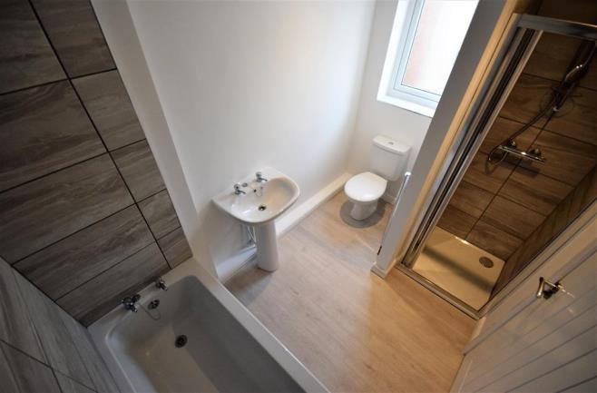 tiles, a glazed bi-folding screen and stainless steel shower attachments, a panel bath complete with stainless steel tap fitments and both a low level W/c and