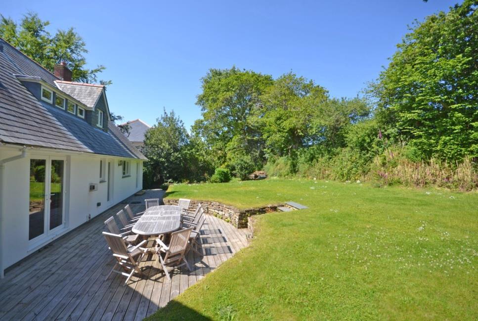 11 On the other side of the house a narrow lawn leads past the hedging and around to the rear where there is a further large lawn backing onto a Cornish stone hedge topped by lovely native trees and