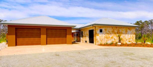 It features four generous bedrooms, walk in robe and ensuite to the master bedroom, open plan living with a feature sandstone coloured wall housing a two way wood heater, an innovative kitchen with