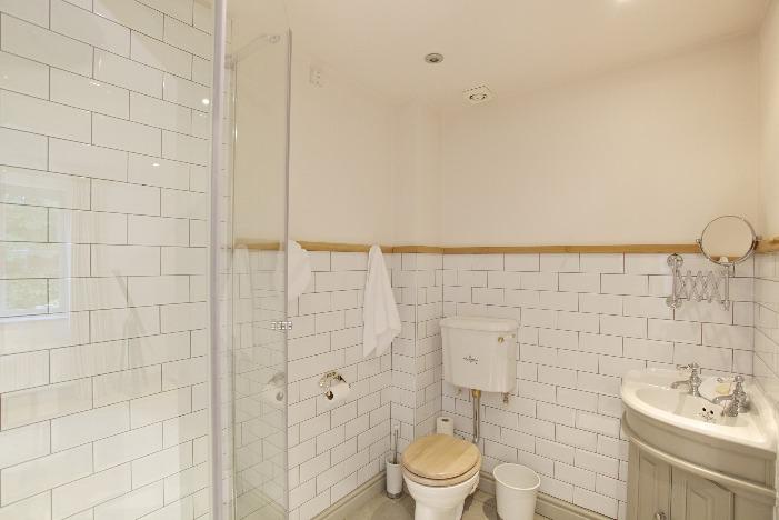 Door into: En Suite Comprising wash basin having vanity storage below, WC and corner shower, having tiled floor and half