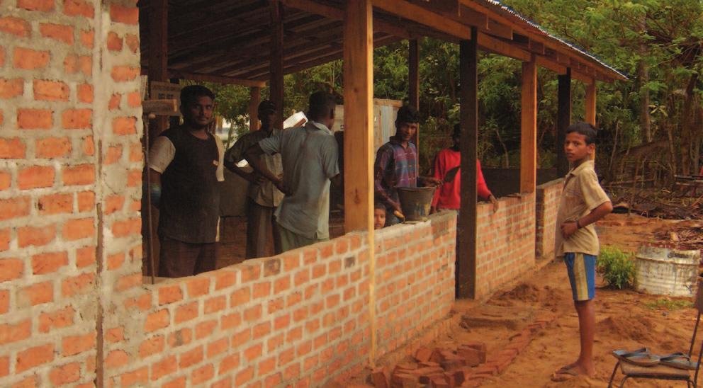 Parents and children work together with Relief International to build a school in post-tsunami Sri Lanka. The school's design is based on a design from the Creative Commons Developing Nations License.