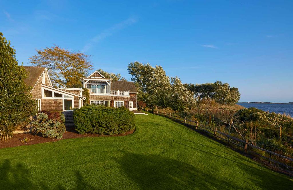 WATERFRONT LIVING Exhibiting outstanding beach-style landscaping throughout, the plot is gracefully adorned with lush green lawns and mature trees that are a delight in each of the seasons.