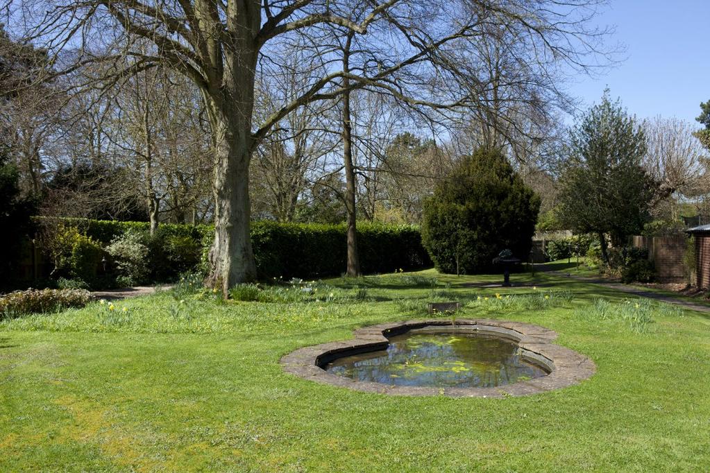 Attractive landscaped gardens with mature trees surround the house. The front garden has an ornamental pond, lawns and attractive rockery with spring bulbs, a variety of alpines and flowering shrubs.