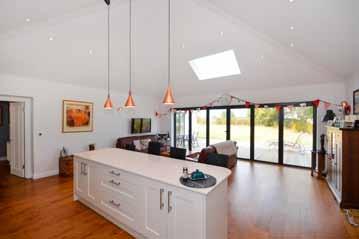 kitchen, dining and living space with a vaulted ceiling.