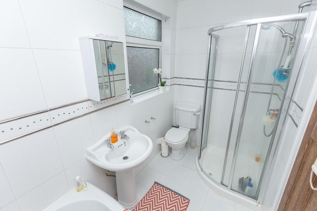 BATHROOM White suite comprising corner bath, enclosed shower